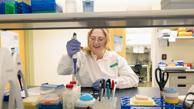 A student within the accelerated master's program working in the biology lab